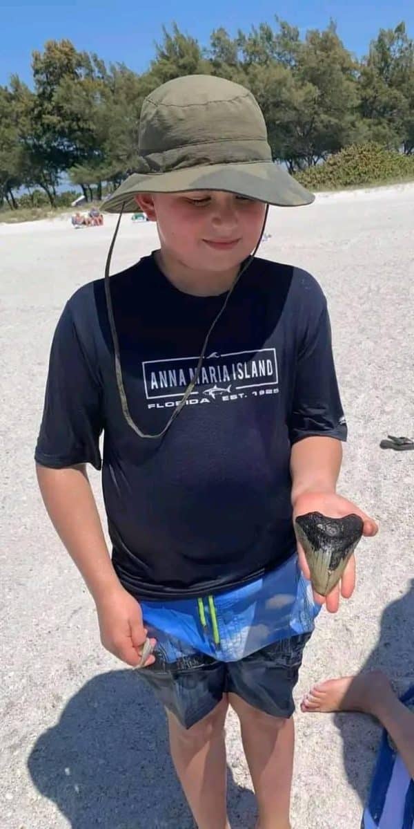 Boy with sharks tooth on Coquina Beach